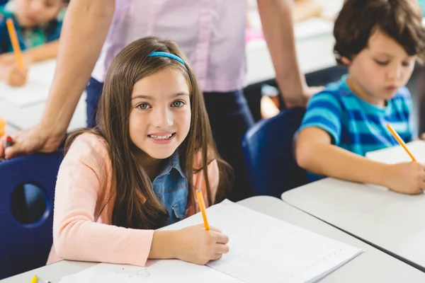 Chica de la escuela haciendo la tarea en el aula — Foto de Stock