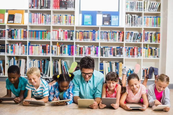 Öğretmen ve çocuklar dijital tablet Kitaplığı'nda kullanma — Stok fotoğraf
