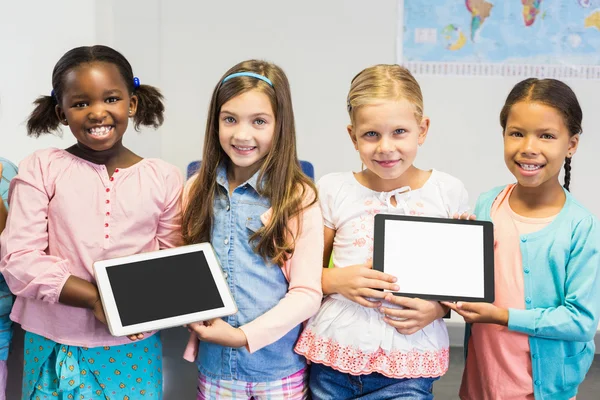 Portrait of students holding digital tablet in classroom — Stock Photo, Image