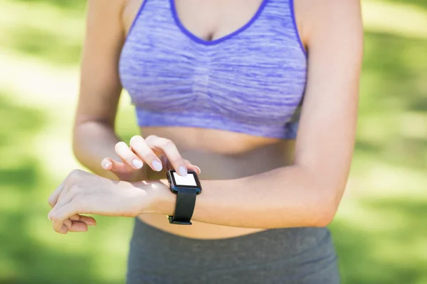 Partie médiane de la femme vérifiant le temps pendant l'exercice — Photo