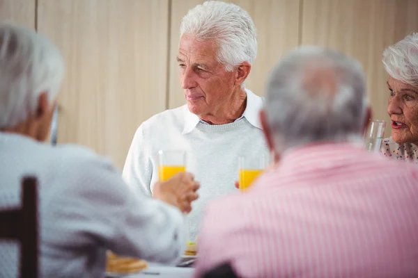 Pessoas idosas que tomam uma bebida de suco de laranja — Fotografia de Stock