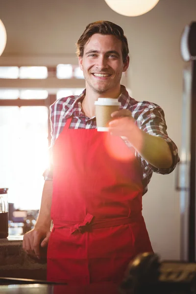 Portrét číšník nabízí šálek kávy — Stock fotografie