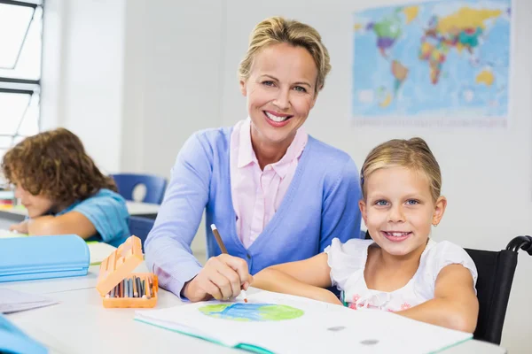 Lärare att hjälpa skolflicka med hennes läxor i klassrummet — Stockfoto