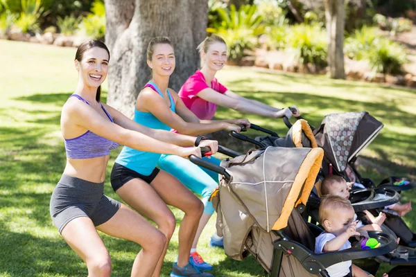 Women exercising with baby stroller — Stock Photo, Image