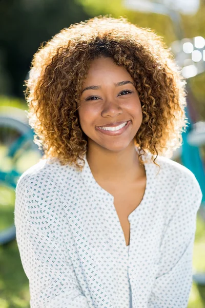 Happy woman sitting in park — Stock Photo, Image