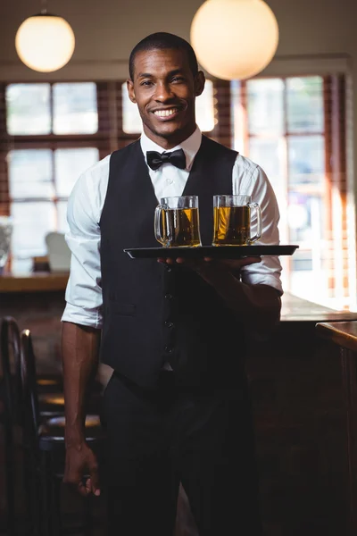 Barman drží tác s brýlemi piva — Stock fotografie