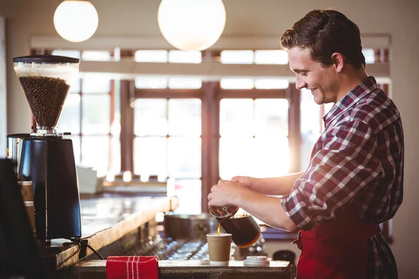 Leende servitör hälla en kopp kaffe — Stockfoto