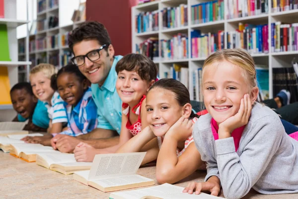 Nauczyciel i dzieci, czytanie książki w bibliotece — Zdjęcie stockowe