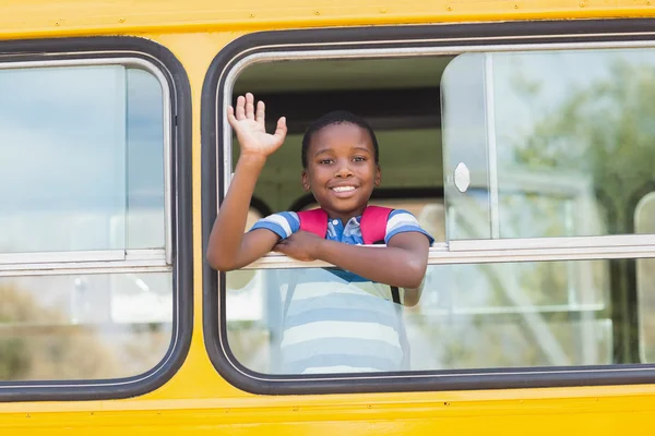 Portrait of schoolboy waving hand from bus — Stock Photo, Image