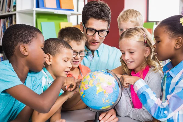 Teacher and kids discussing globe — Stock Photo, Image