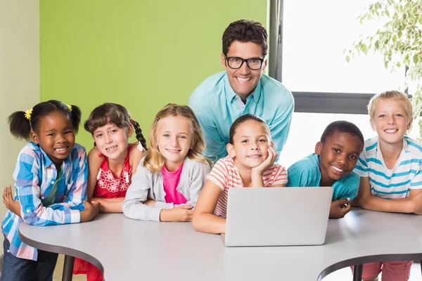 Portrait de l'enseignant et des enfants utilisant un ordinateur portable dans la bibliothèque — Photo