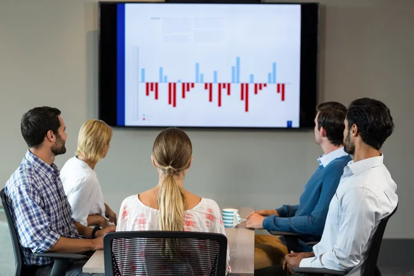 Geschäftsleute diskutieren bei einem Meeting über Grafik — Stockfoto