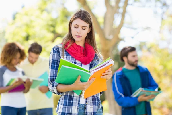 Faculdade menina ler notas com amigos no fundo — Fotografia de Stock