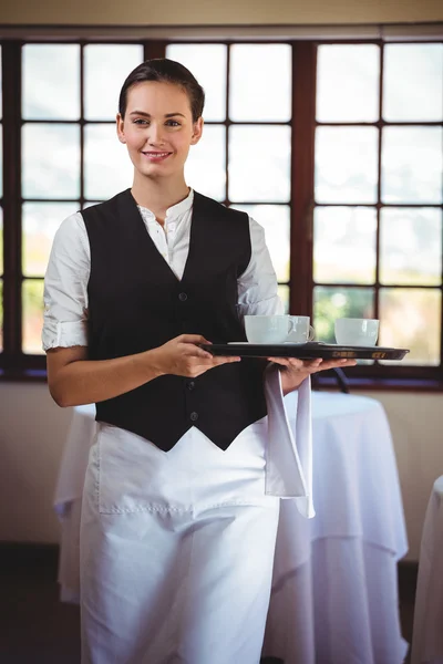 Portret van lachende serveerster houden een lade voor koffie cups — Stockfoto
