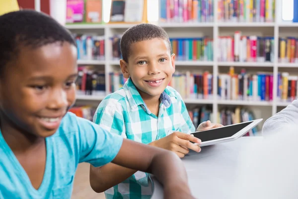 Crianças usando tablet digital na biblioteca — Fotografia de Stock