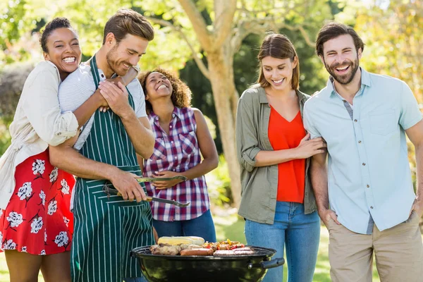 Щасливі друзі готують гриль для барбекю в парку — стокове фото