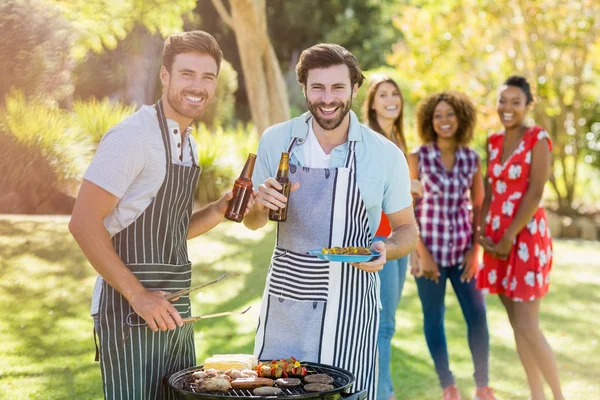 Dos hombres sosteniendo una botella de cerveza — Foto de Stock