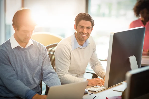 Man working on computer with coworker — Stock Photo, Image
