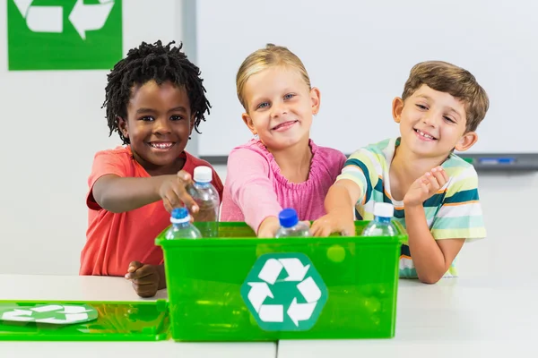 Děti drží recyklovaných lahví v učebně — Stock fotografie