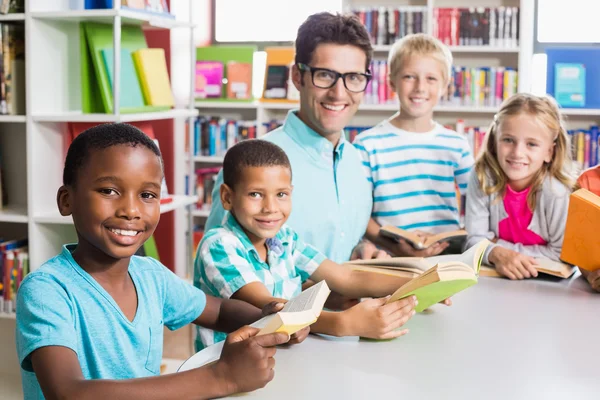 Retrato del profesor y los niños en la biblioteca — Foto de Stock