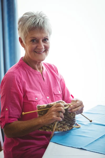 Femme souriante à la retraite faisant du tricot — Photo