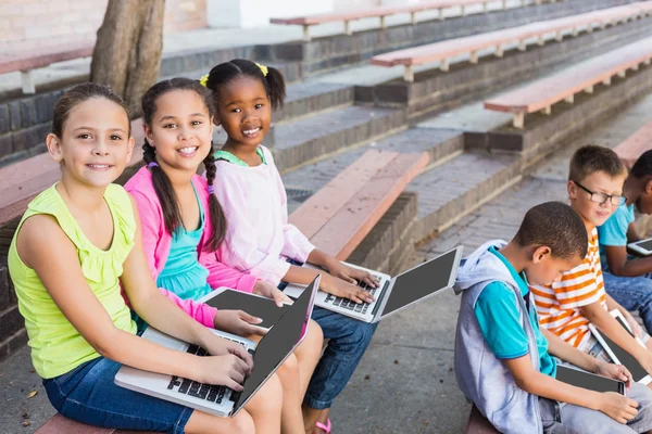 Enfants assis sur le banc et utilisant un ordinateur portable — Photo