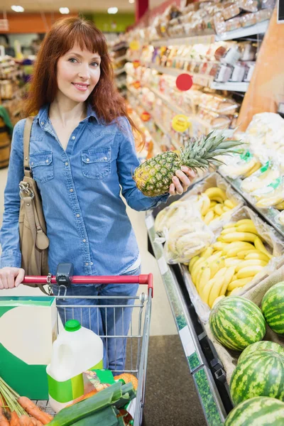 Bir ananas tutarak müşteri gülümseyen — Stok fotoğraf
