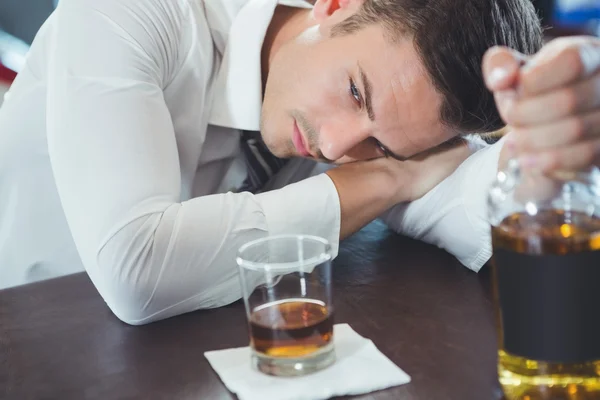 Berusad man som ligger på en bar counter — Stockfoto