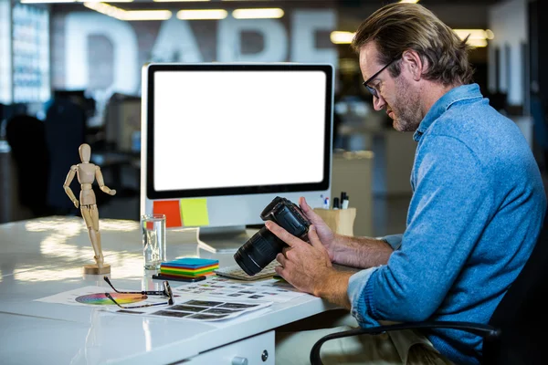 Creative businessman holding camera — Stock Photo, Image