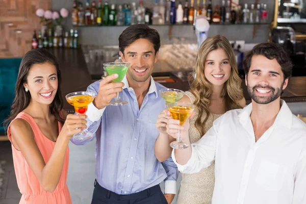 Glückliche Freunde stoßen mit Cocktailgläsern an — Stockfoto