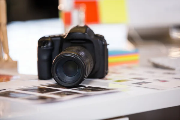 Camera on photographs at desk — Stock Photo, Image