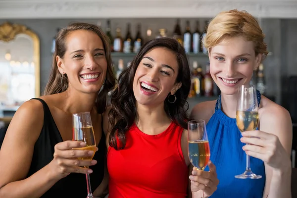 Felices amigas sosteniendo una copa de flauta de champán — Foto de Stock