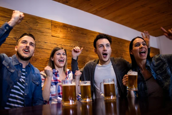 Amigos disfrutando con tazas de cerveza — Foto de Stock
