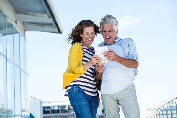 Alegre pareja leyendo mapa — Foto de Stock