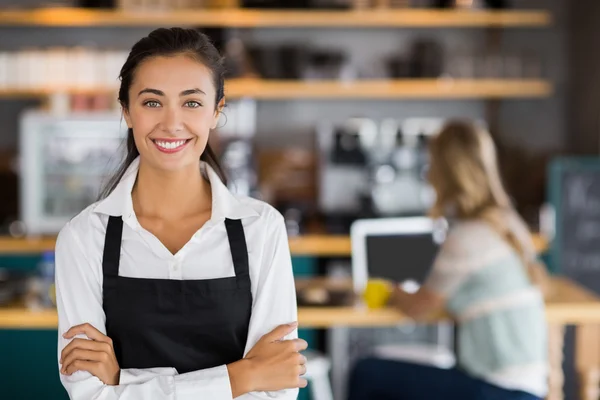 Портрет улыбающейся официантки стоящей со скрещенными руками — стоковое фото