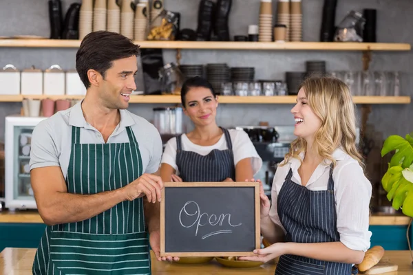 Colleagues showing chalkboard with open sign — Stock Photo, Image