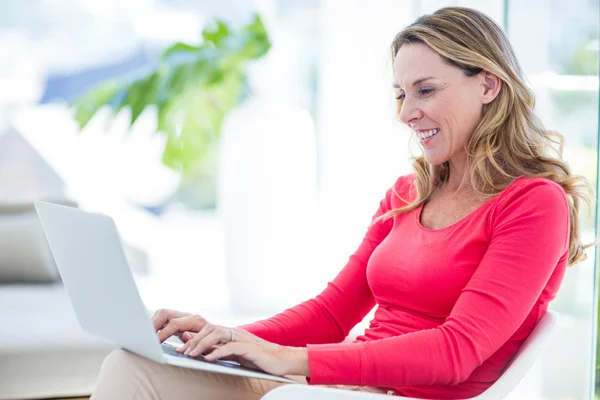 Mulher sorrindo ao usar laptop — Fotografia de Stock