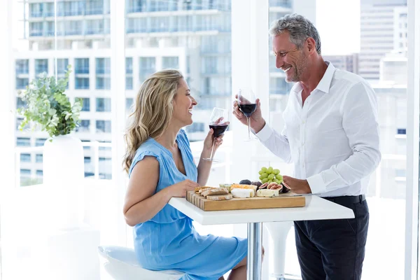 Casal maduro segurando vinho tinto — Fotografia de Stock