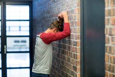 stressed man leaning on wall clipart