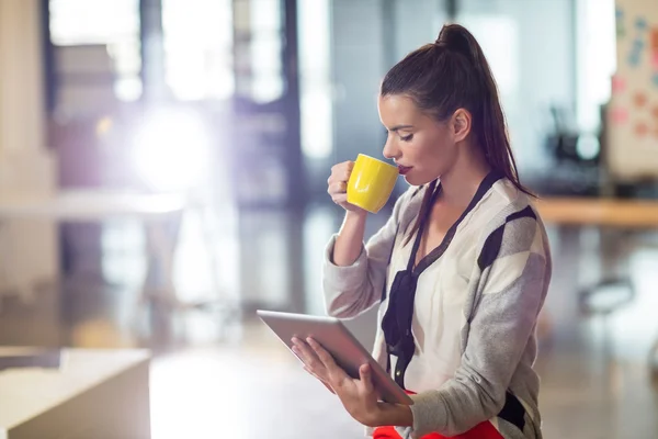 Woman drinking coffee in office — Stock Photo, Image