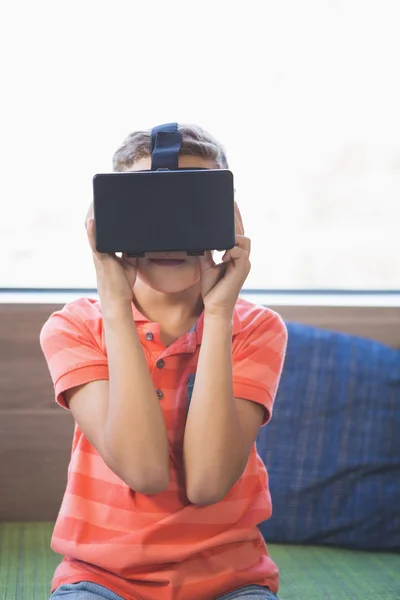 Miúdo da escola usando óculos de realidade virtual na biblioteca — Fotografia de Stock