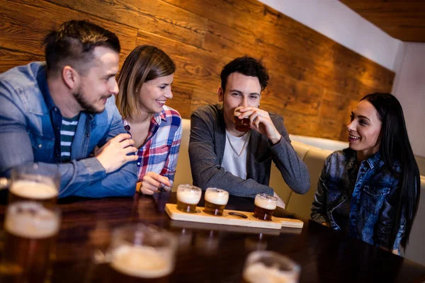 Amigos tomando cerveja à mesa — Fotografia de Stock