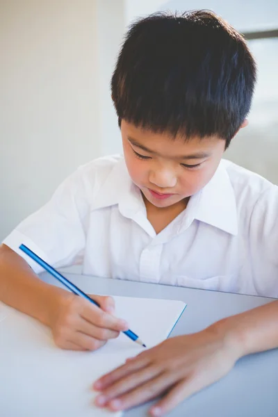 Schoolboy doing homework in classroom — Stock Photo, Image