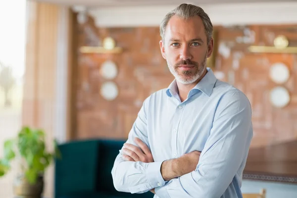 Övertygad om man står med armarna korsade i restaurang — Stockfoto