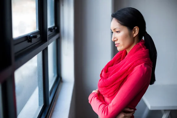 Жінка стоїть біля вікна в офісі — стокове фото