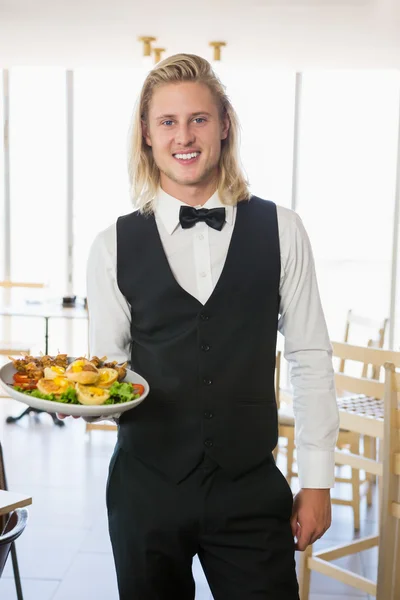 Waiter holding a plate of food in restaurant — Stock Photo, Image