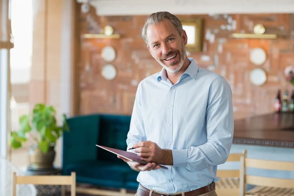 Retrato de homem sorridente escrevendo em um arquivo — Fotografia de Stock