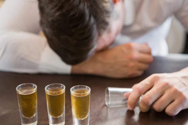 Hombre borracho durmiendo en un mostrador de bar — Foto de Stock