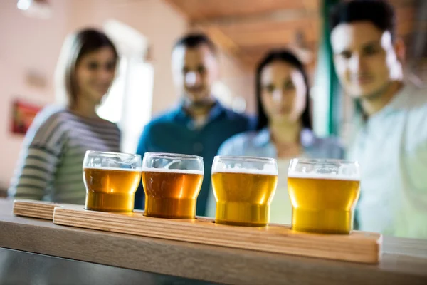 Amigos na frente do amostrador de cerveja — Fotografia de Stock