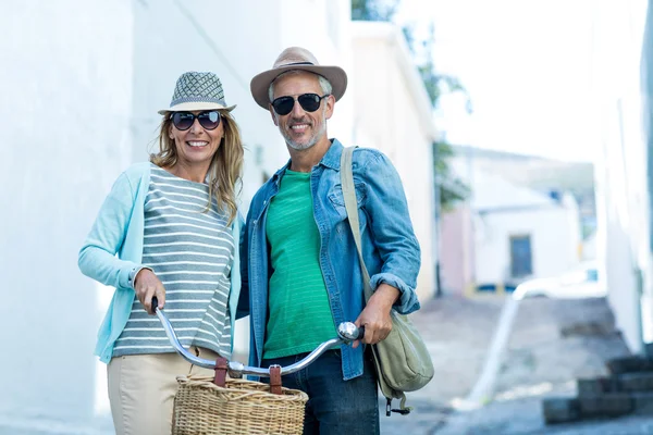 Mature couple with bicycle standing — Stock Photo, Image